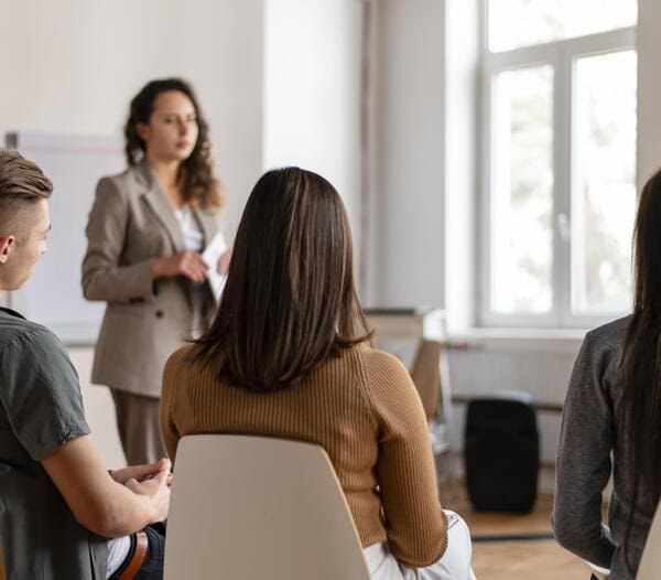 Atelier thématique de sophrologie avec la sophrologue qui explique et les participants qui écoutent.